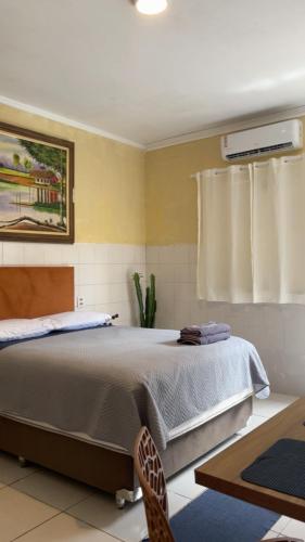 ein Schlafzimmer mit einem großen Bett und einem Stuhl in der Unterkunft Kitnet 17D in São Luís