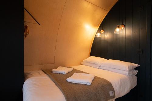 two beds in a room with two towels at Hillend by Wigwam Holidays in Todmorden