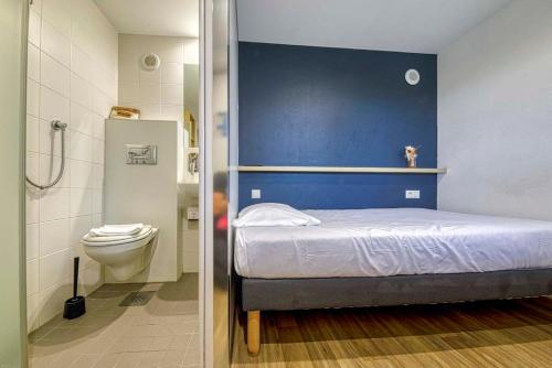 a small bedroom with a bed and a toilet at UNISOTEL Le Havre in Le Havre