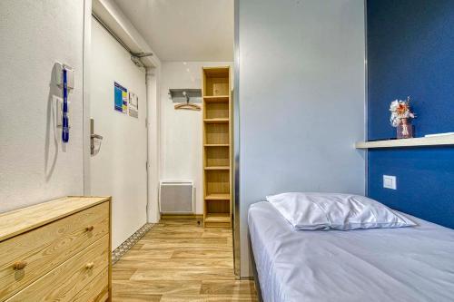 a small bedroom with a bed and a closet at UNISOTEL Le Havre in Le Havre