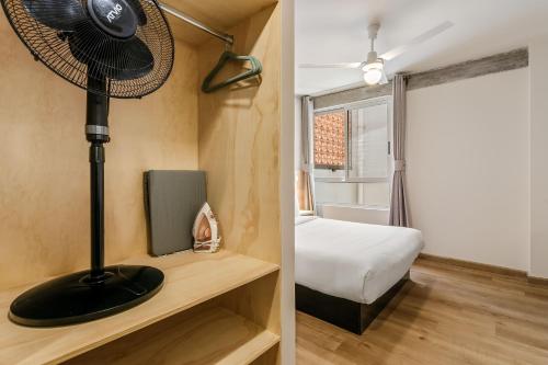 a room with a bed and a fan on a table at El Pocito by Homirent in El Jacal