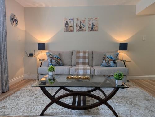 a living room with a couch and a table at Modern, private & luxurious executive suite in Delta