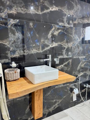 a bathroom with a white sink on a wooden counter at Pool House et Rooftop Hammamet in Dar Hamad Jedidi