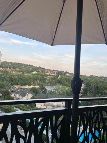 a white umbrella on a balcony with a view at Anonim Plus in Vrdnik