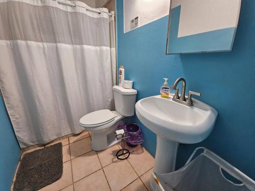 a blue bathroom with a toilet and a sink at Above the Plaza 6 (with A/C) in Rincon