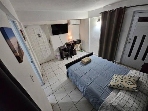 a small bedroom with a bed and a television at Above the Plaza 6 (with A/C) in Rincon