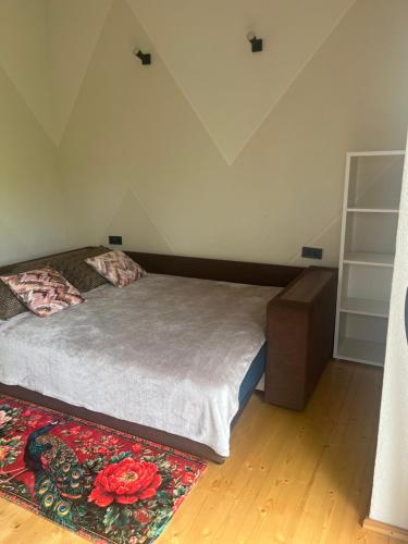 a bedroom with a bed and a rug on the floor at Shark in Liepāja