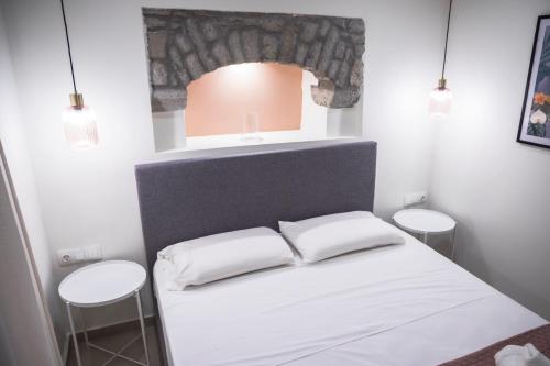 a small room with a bed with two stools at Akrolithos apartments 1st floor in Platy