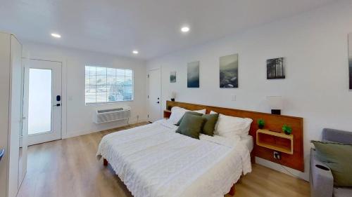 a white bedroom with a large bed and a window at Hygge Hus Hotel in Andrews
