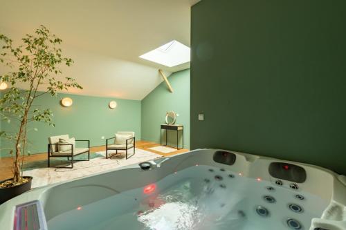a bath tub in a room with a green wall at Casa Miasto - Chambres d'hôtes & Spa in Aspet
