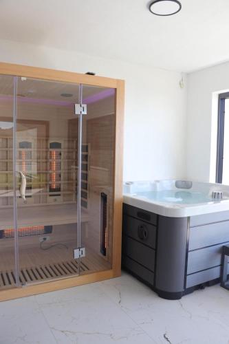 a bathroom with a bath tub and a glass enclosure at Apartment Petra in Starigrad