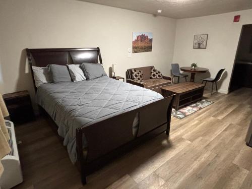 a bedroom with a large bed and a table and chairs at Green River Inn Apartments in Green River