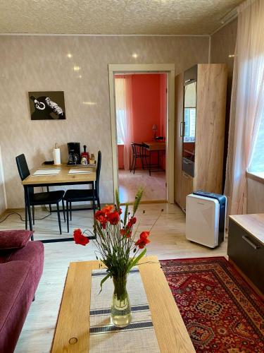 a living room with a vase of flowers on a table at Kauba 6-5 Apartment in Kuressaare