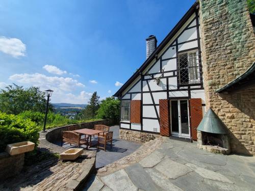 a house with a picnic table and a building at Ferienhaus am Rursee - Haus Eiche in Simmerath