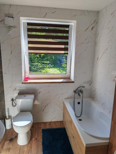 ein Badezimmer mit Toilette, Badewanne und Fenster in der Unterkunft Potok in Walim