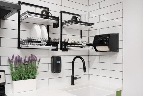 a bathroom with black shelves above a sink at Samesun Vancouver in Vancouver