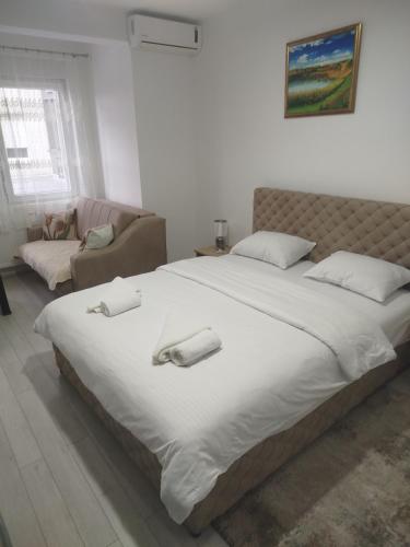 a bedroom with a large bed and a couch at Vea in Banja Koviljača