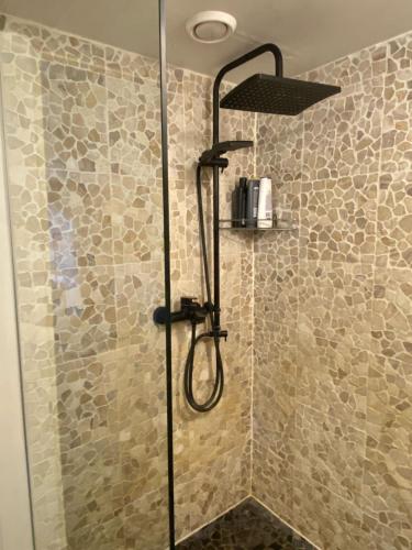 a shower with a shower head in a bathroom at Old town Stylish Stonehouse Kauba 6a in Kuressaare