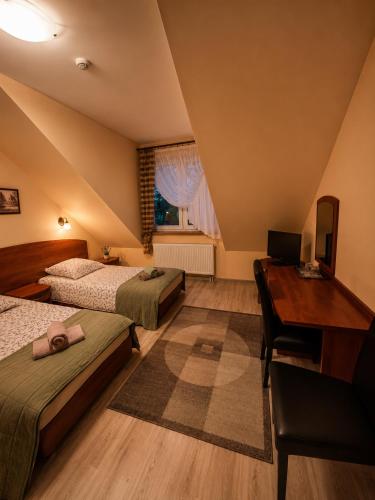 a hotel room with two beds and a desk and a desk at Zajazd Alicja in Nowe Bagienice