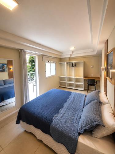 a bedroom with a blue bed and a window at Hotel Cantareira in Niterói
