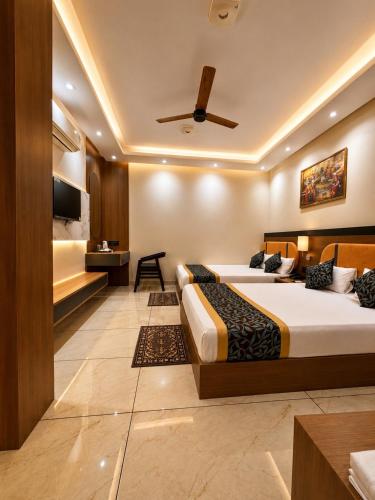 a hotel room with two beds and a tv at Hotel Shakuntla Palace - 400 Meters away from Vishnu Pad Temple 7 mins walk in Gaya
