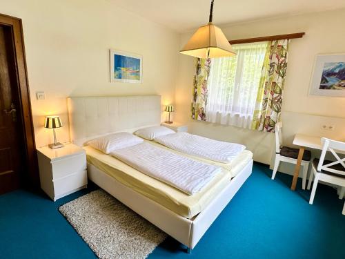 a bedroom with a large white bed and a table at Berghof Werfenweng in Werfenweng