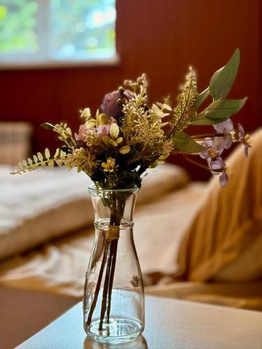 a glass vase with flowers in it on a table at Remizovka Mount in Almaty