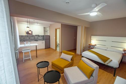 a bedroom with a large bed and a kitchen at Estudios Aránzazu in Santander