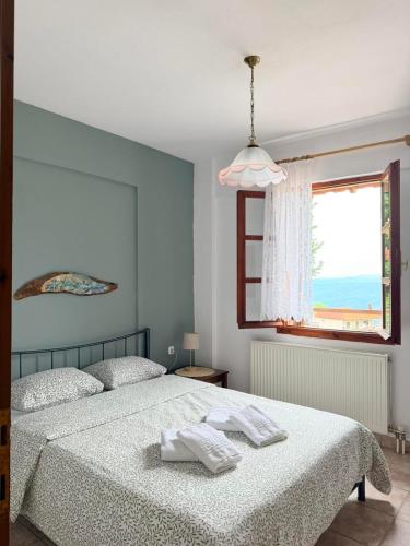 a bedroom with a bed with two towels on it at Portitsa View Guesthouse in Spílaion