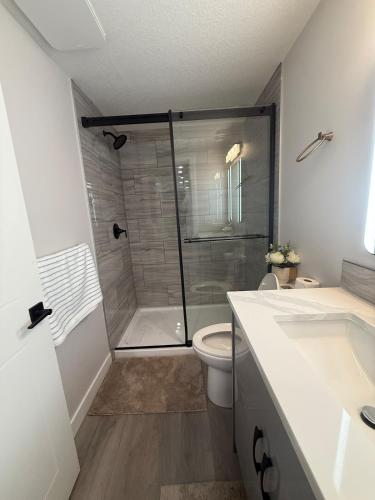 a bathroom with a shower and a toilet and a sink at Cozy Suite Near Airport in YYC