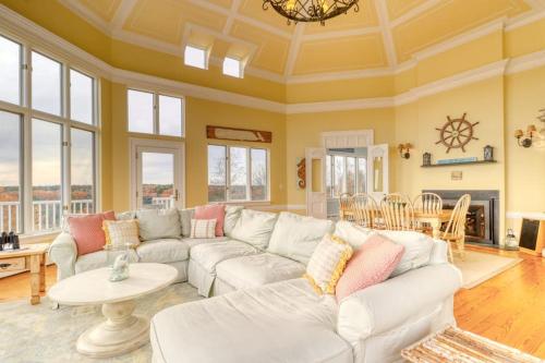 a living room with a white couch and a table at Bayfront home with 270-degree views, large deck & porch - near Popham Beach in Phippsburg