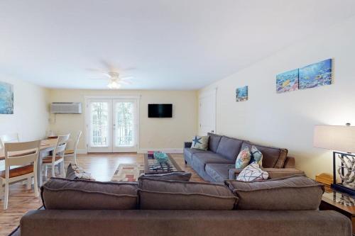 a living room with a couch and a table at Stylish Condo at Sheepscot Harbor Resort w/Free WiFi, River Views, & Balcony in Edgecomb