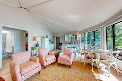 a living room with a table and chairs at Unique oceanfront home with a deck, tons of natural light, & amazing views in Wiscasset