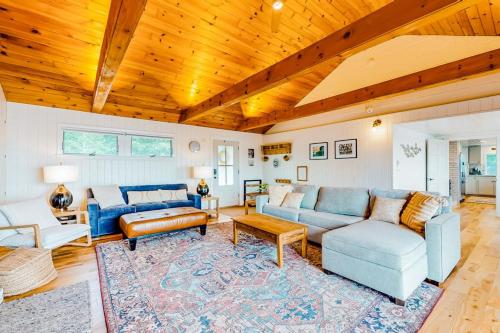a living room with couches and a wooden ceiling at Renovated oceanfront home with stunning view & pebbly beach - snowbird-friendly in Saint George