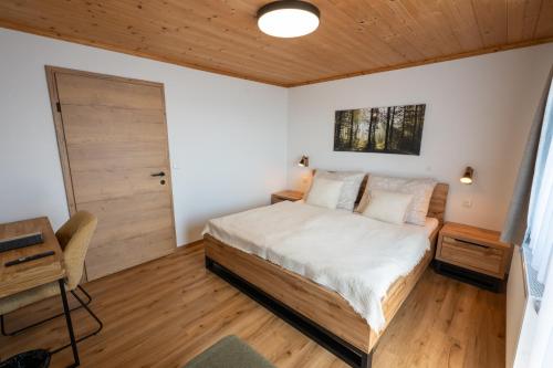 a bedroom with a bed and a wooden ceiling at Ferienwohnung Tiefengraber in Weiz