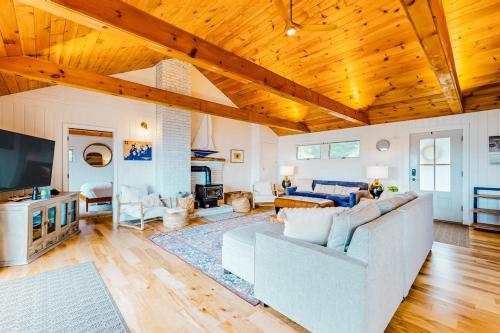 a living room with a white couch and wooden ceilings at Renovated oceanfront home with stunning view & pebbly beach - snowbird-friendly in Saint George