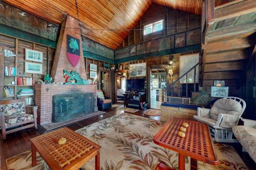 a living room with a large fireplace and a table at Spacious Waterfront Estate & Cabins W/ Porch, Fireplace, Kayaks & Free WiFi in Brunswick
