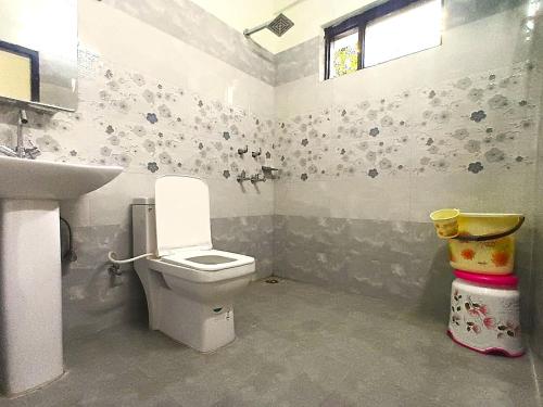 a bathroom with a toilet and a sink at RCA Homestay in Dharmsāla