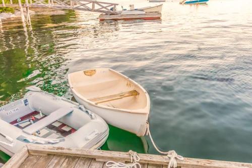 a small boat tied to a dock in the water at Amazing All-Season Sprucewold Cabin w/ Private Beach Club Access Dog-friendly in Boothbay Harbor