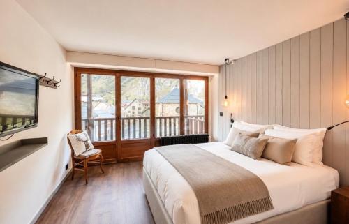 a bedroom with a large bed and a balcony at L'Ecrin de Jade - Valloire in Valloire