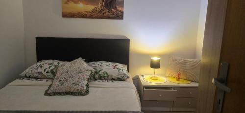 a bedroom with a bed and a nightstand with a lamp at Studio Apartment Loly in Nedeščina
