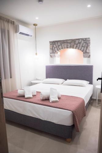 a bedroom with a large bed with white pillows at Akrolithos apartments ground floor in Platy