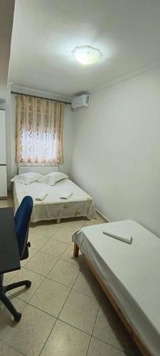 a room with two beds and a chair and a window at DESPOINA APARTMENT with garden in Nea Michaniona