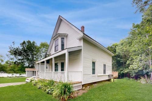 a white house with a porch on a lawn at Charming Camden Retreat with Front Porch, Deck and Wifi in Camden
