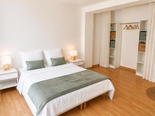 a white bedroom with a large bed and two lamps at L'Escale de Bonny in Bonny-sur-Loire