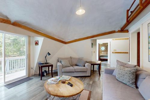 a living room with a couch and a table at Geodesic Dome w/ Riverfront Deck, Lovely Views, & High-Speed WiFi - Dogs Welcome in Boothbay