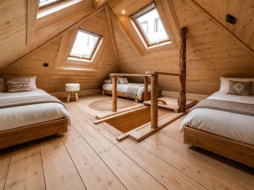 a bedroom with two beds in a wooden cabin at Chalet La Tourelle - Valloire in Valmeinier