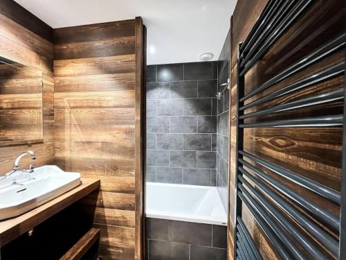a bathroom with a bath tub and a sink at L'Étoile D'or - Valloire in Valloire