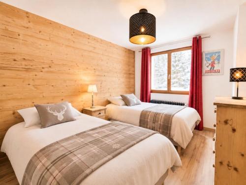 two beds in a room with wooden walls at L'Étoile D'or - Valloire in Valloire