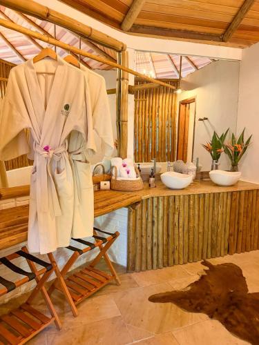 a robe hanging on a rack in a bathroom at Villa Pantai Secret Place in Miracatu